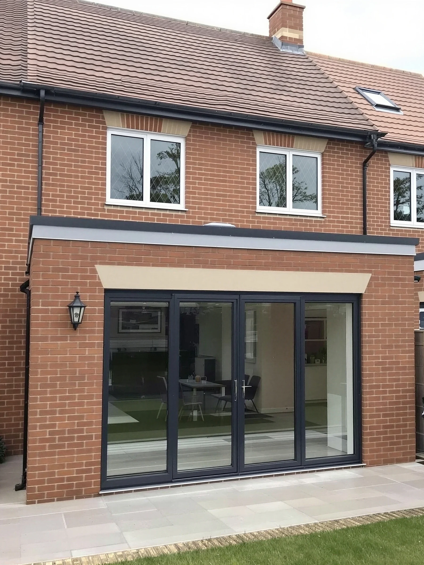 A new flat-roof rear extension in matching red brick with black bi-fold doors